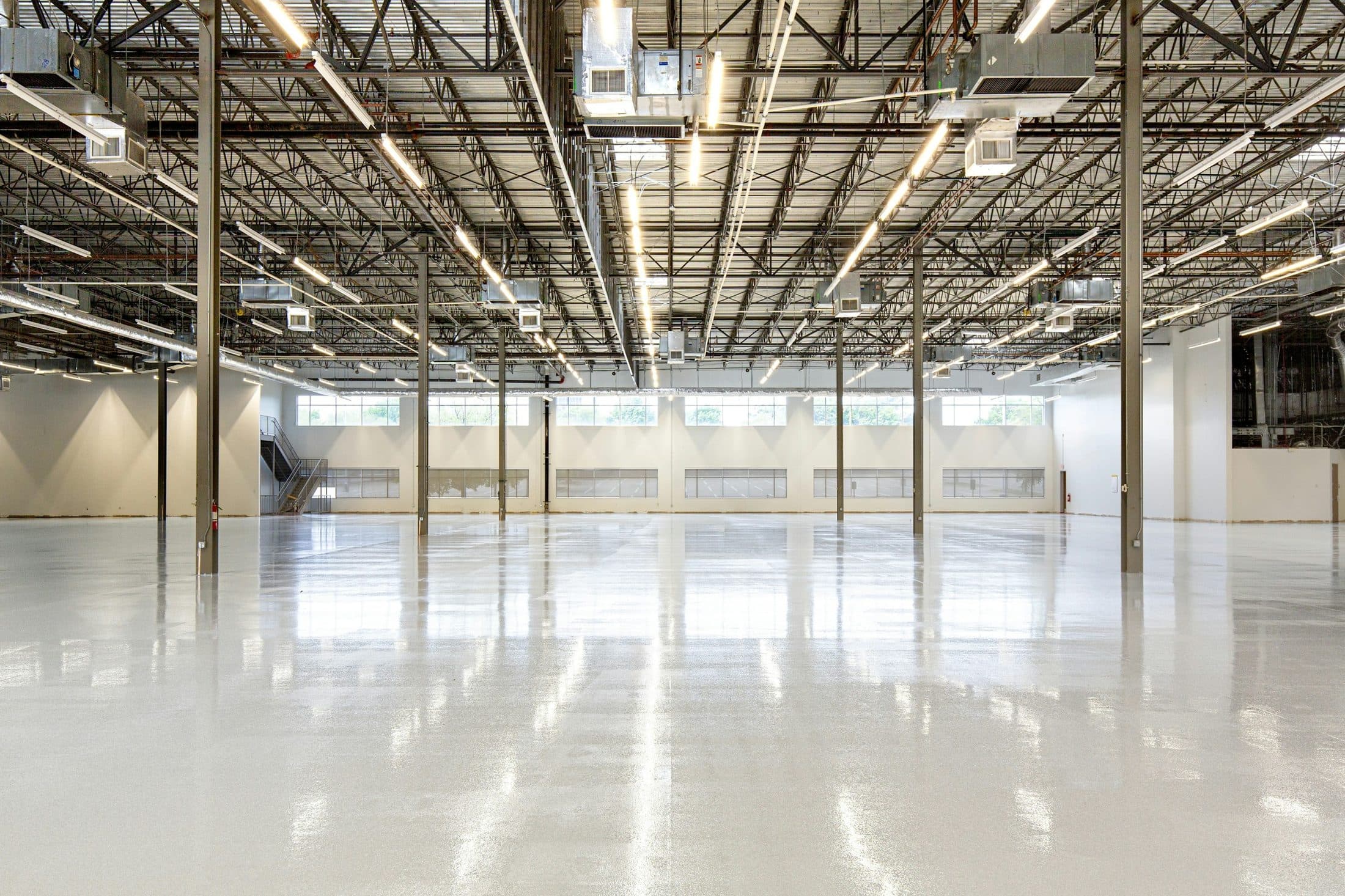 Vaste hall industriel vide au sol de béton poli