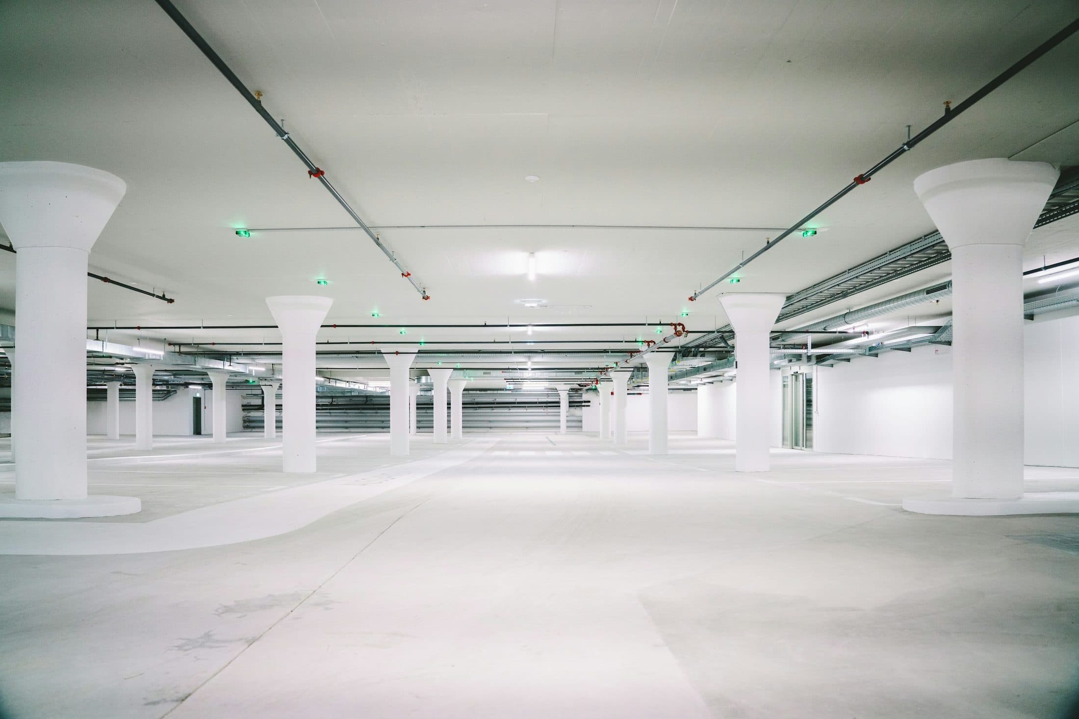 Parking souterrain vide entre des piliers de béton clair