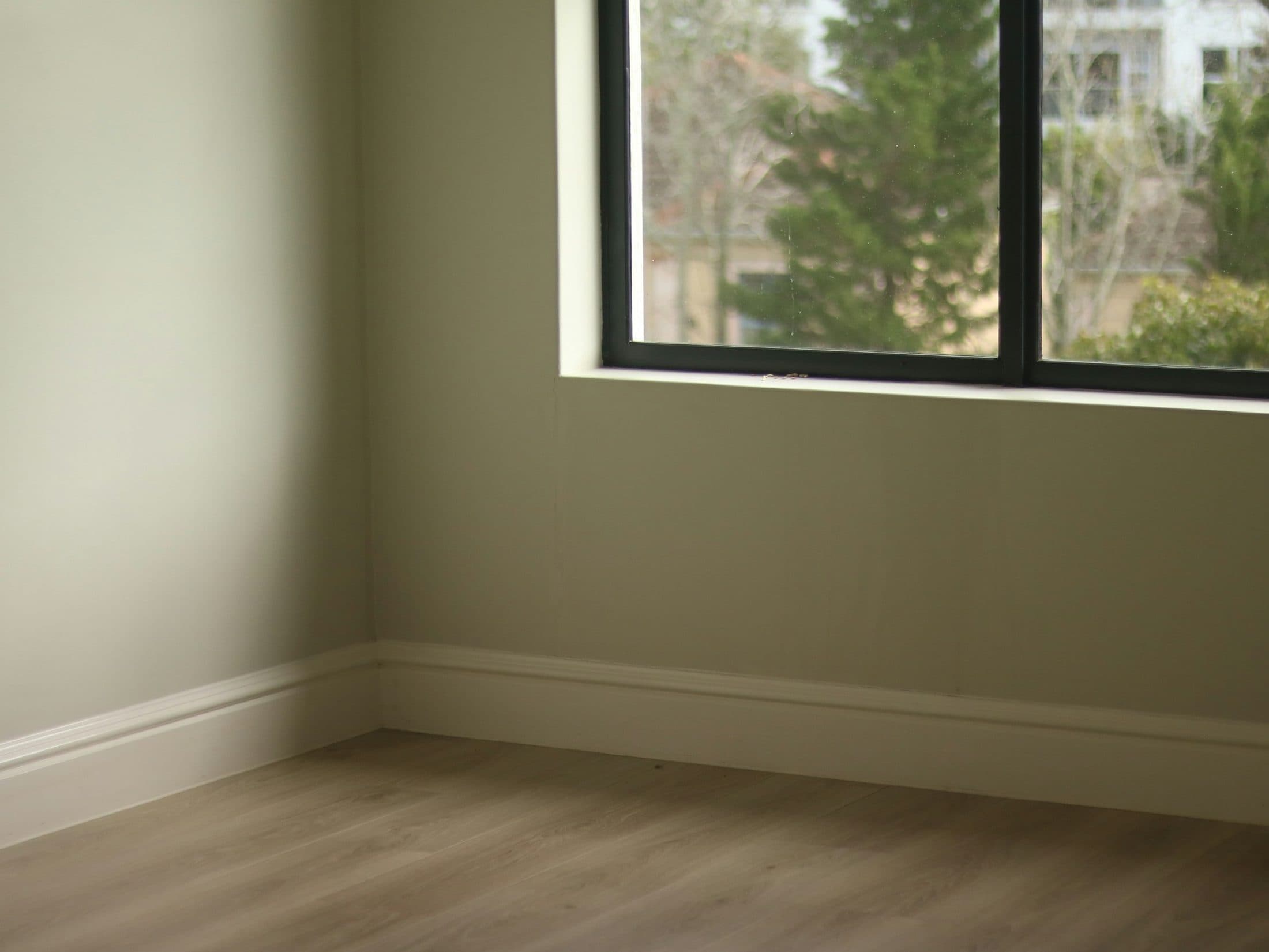 Empty room with pale walls and bare wooden flooring
