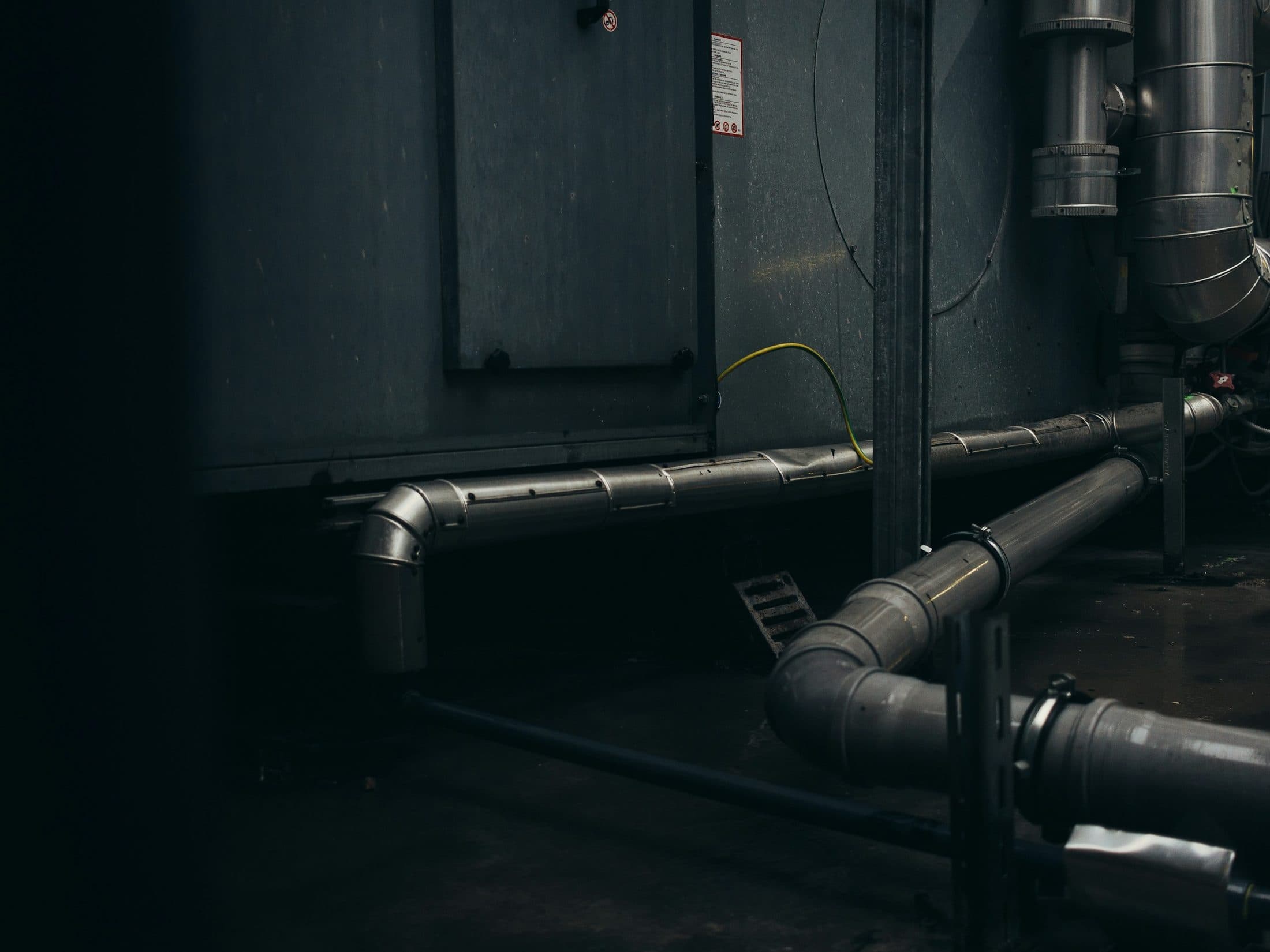 Réseau de gaines de ventilation fixé le long d'un mur
