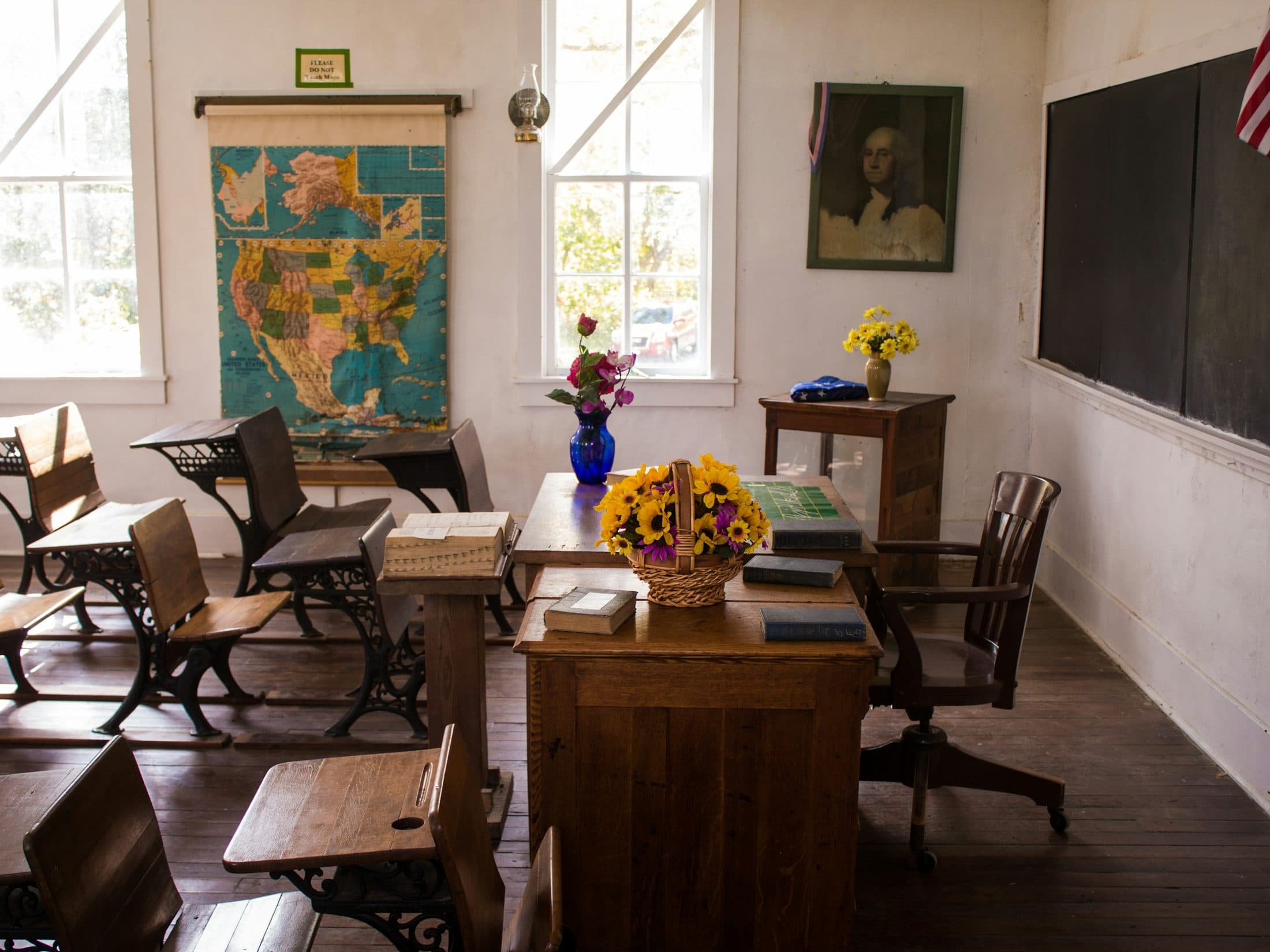 Salle de classe vide, tables et chaises alignées face au tableau