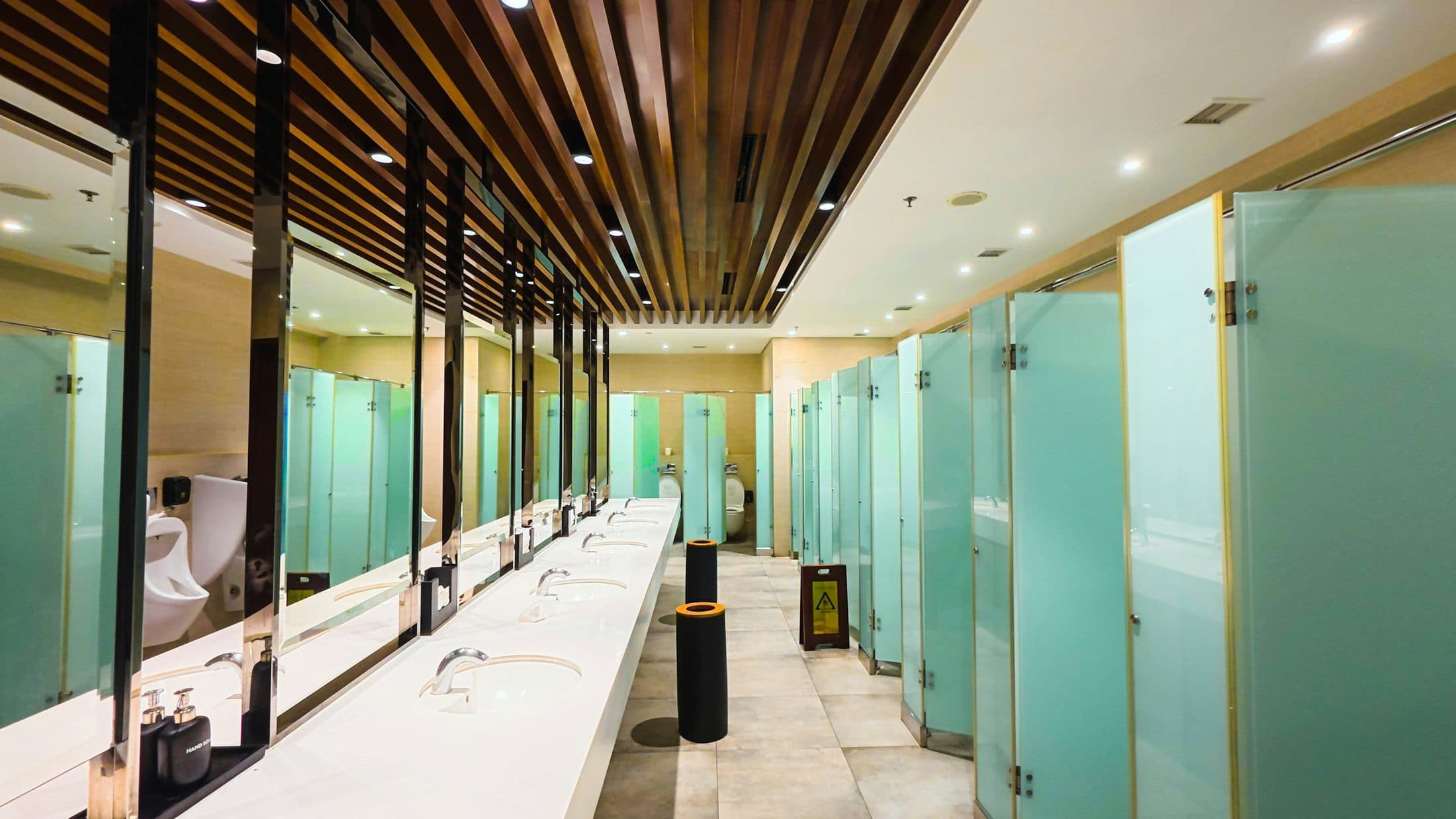 Shared washroom with basins, mirrors and glass-panelled cubicles
