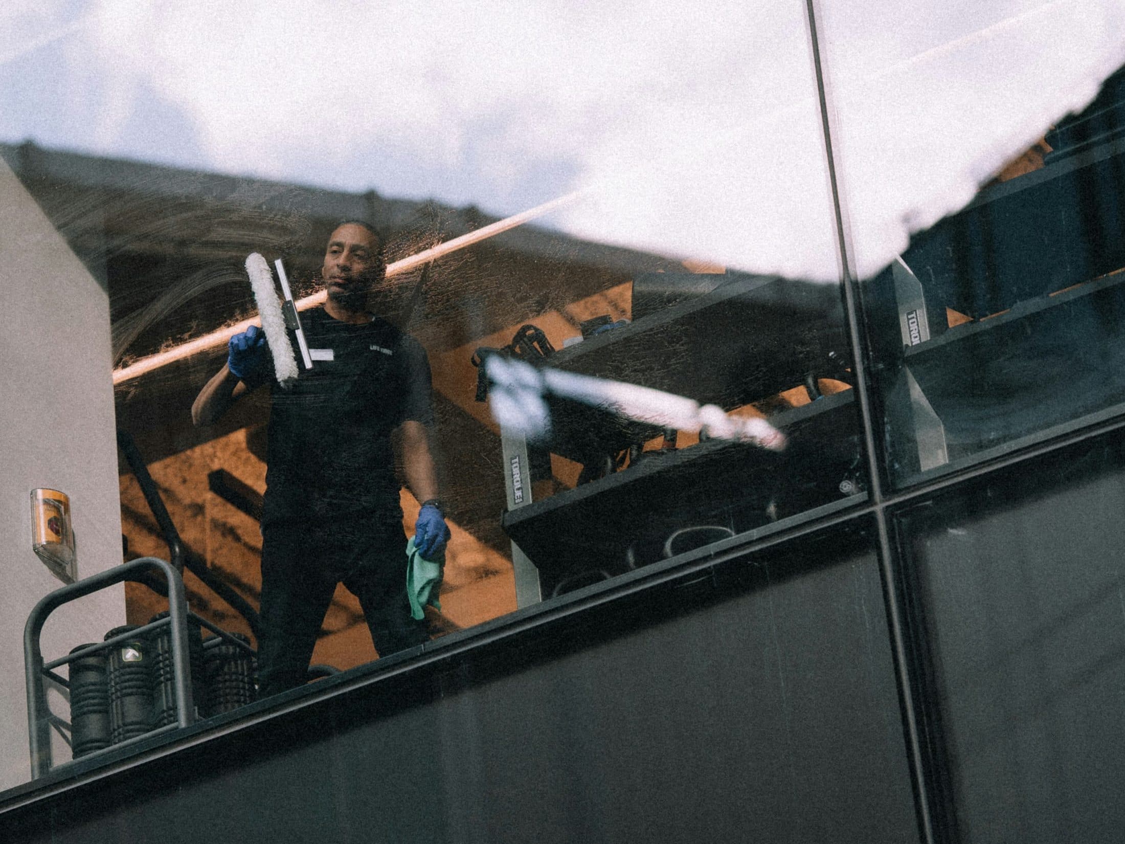Window cleaner at work behind a glass façade